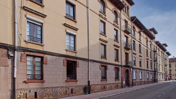 En bygning med flere etager i samme arkitektoniske stil, med flere vinduer og altaner.