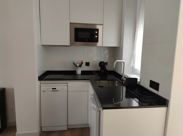 A modern kitchen with a dishwasher, a microwave, and a stove.