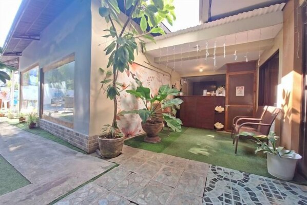 A building with a patio area, potted plants, a seating area, and a reception desk. - Bohol Casa Nino Alona Resort (Panglao)