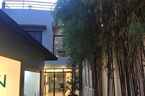 A building with a glass entrance, a balcony, and a vertical garden. - Bohol Casa Nino Alona Resort (Panglao)