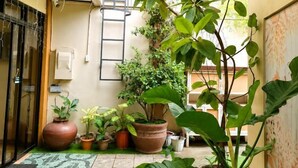 A small courtyard with potted plants, a tiled floor, and a door. - Bohol Casa Nino Alona Resort (Panglao)