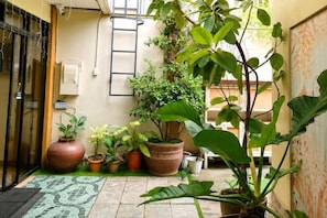 A small courtyard with potted plants, a tiled floor, and a door. - Bohol Casa Nino Alona Resort (Panglao)