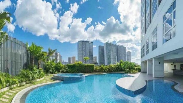 Una piscina con un paisaje urbano al fondo.