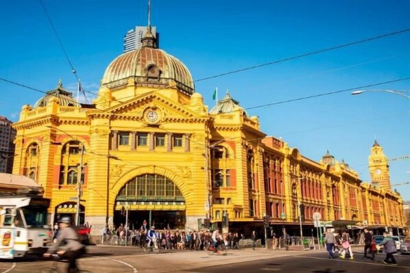 Un edificio grande y amarillo con una cúpula destacada y una entrada arqueada, probablemente una estación de tren o edificio público.
