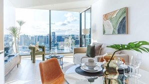 Una sala moderna con vistas a la ciudad, una mesa de comedor con sillas y un sofá.