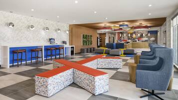 A modern lobby with a checkered floor, seating areas, a reception desk, and a bar.