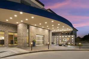 Un hôtel à la façade en briques, doté d’une entrée en arc de cercle et d’une enseigne indiquant « GLO BEST WESTERN ».