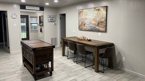 Un coin repas avec une table et des chaises en bois, un buffet en bois et un tableau accroché au mur.