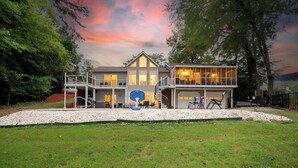 A two-story house with a large garage and a covered outdoor area. - Heated Pool, Hot Tub, Game Rm, Boat Dock, Lakefront Views (Lake Norman of Catawba)