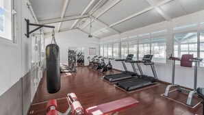 Ett gym med löpband, motionscyklar och en boxningssäck.