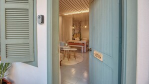 A room with a wooden table and chairs, a small rug, and a door labeled "Agriculture." - Agrius - Elegant Studio & Balcony in Batroun (Batroun)