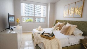 A modern bedroom with a bed, bedside table, and a large window. - Midtown Miami Condo with Free Parking (Miami)