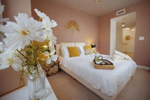 A bedroom with a bed, bedside table, and a vase of flowers. - Midtown Miami Condo with Free Parking (Miami)