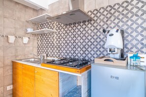 Frigorífico, placa de cocina, cafetera o tetera y trona infantil