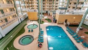 Un hotel con varias piscinas, mobiliario exterior y un patio central.