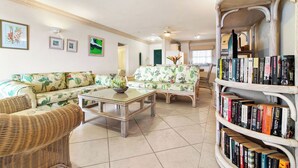 Ein Wohnzimmer mit einer Couch, einem Couchtisch und einem Bücherregal voller Bücher.