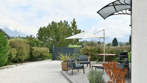 Un patio con mobili da esterno, un barbecue e vista sulla campagna.