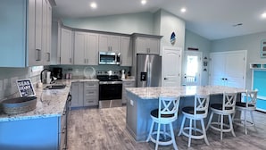 A modern kitchen with grey cabinets, stainless steel appliances, and a marble countertop. - 2 BR Retreat by the waterfront in 
Little River, SC (Little River)