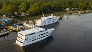 Two large cruise ships docked at a pier with a forested area in the background. - 2 BR Retreat by the waterfront in 
Little River, SC (Little River)