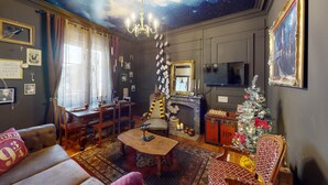 Una sala de estar acogedora con chimenea, árbol de Navidad y televisor.