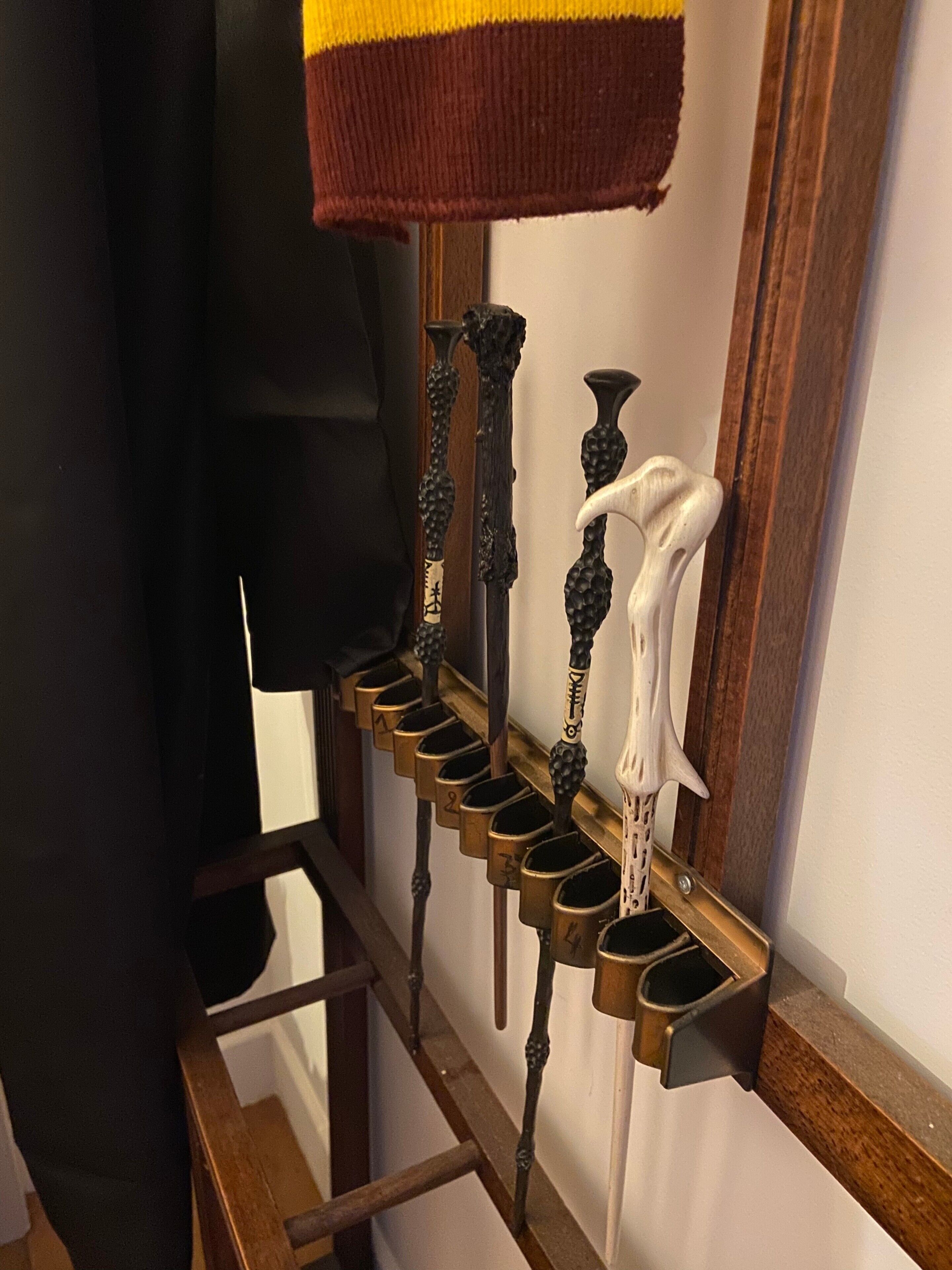 Una escalera de madera con barandilla de metal y pared blanca.