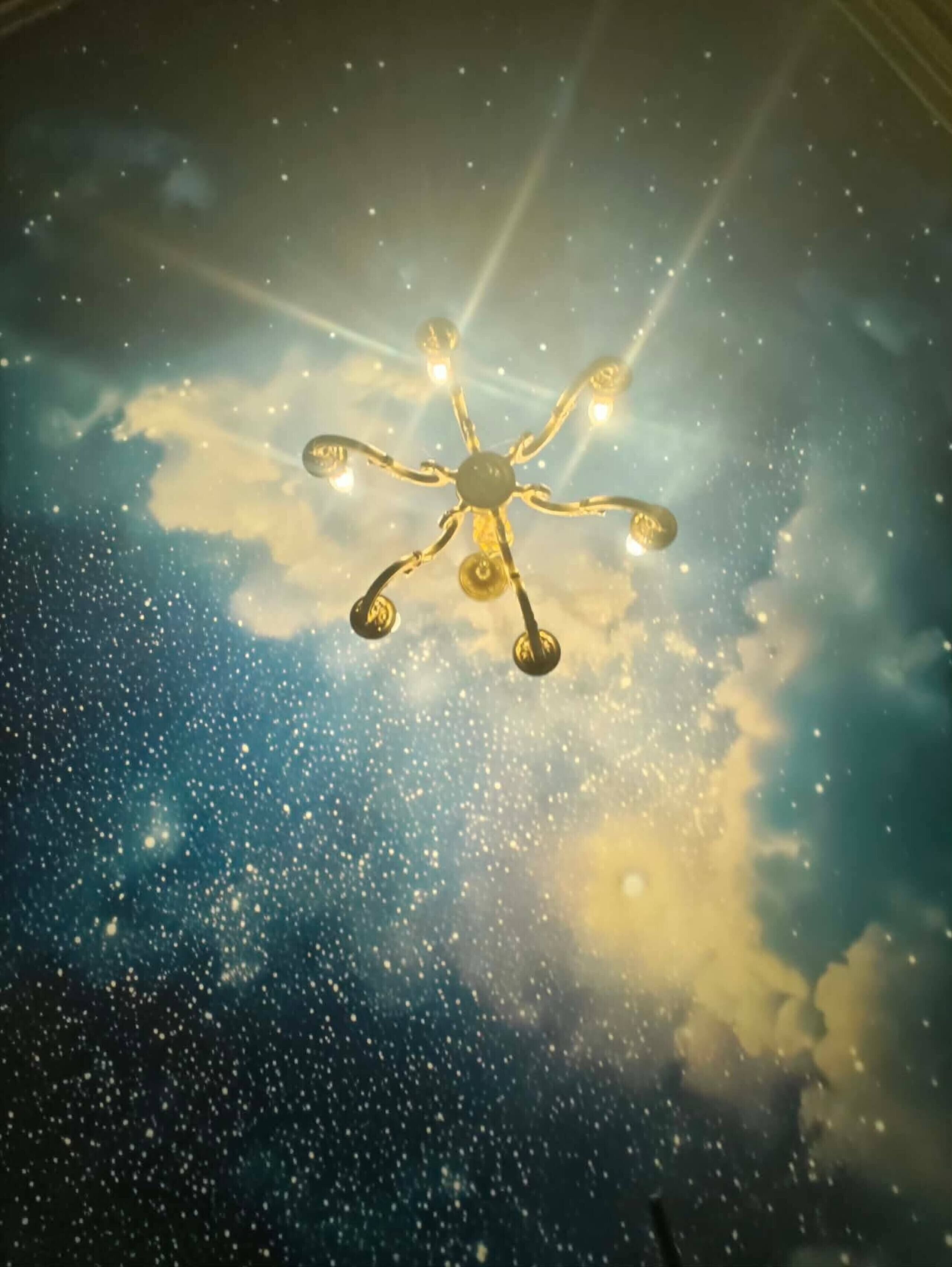 A ceiling with a starry sky design and a central light fixture.