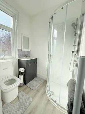 Een douche, handdoeken, toiletpapier
