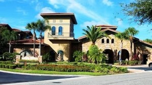 A large, two-story house with a stone facade, arched windows, and a well-maintained garden. - Pool view condo minutes to Disney World (Davenport)