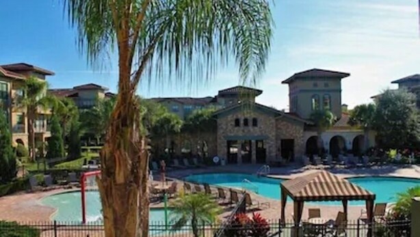 A resort with a swimming pool, lounge chairs, and a gazebo. - Pool view condo minutes to Disney World (Davenport)