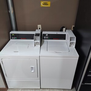 Two Speed Queen commercial washers in a utility room with a sign above them reading "Guest Laundry". - STAY MORE, SPEND LESS (Kutztown)