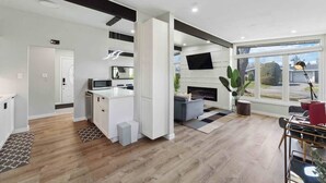 Una cocina moderna con armarios blancos, microondas integrado y una isla central.
