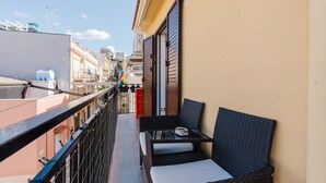 A balcony with wicker furniture, a table, and a chair. - Casa Luna with Private Terrace, Wi-Fi and Air Conditioning (Balestrate)