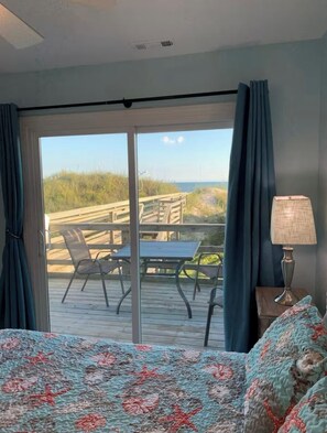 Een kamer met een grote schuifdeur die uitkomt op een terras met een tafel en stoelen.