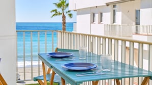 Ein Balkon mit Tisch für zwei Personen, mit Blick auf das Meer.