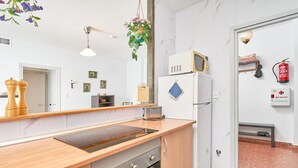 Eine moderne Küche mit Holzarbeitsplatte, Edelstahlgeräten, einer Mikrowelle und einem Kühlschrank.