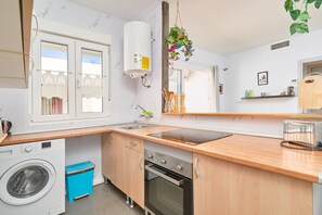 Una cocina compacta con lavadora, horno y ventana con vistas.