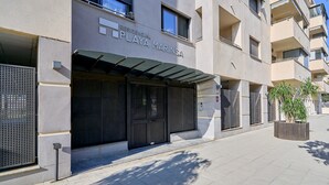 Un edificio residencial llamado 'RESIDENCIAL PLAYA MARINSA' con entrada cubierta y acceso mediante portón.