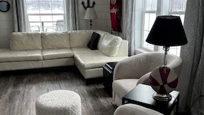 A modern living room with a sectional sofa, a round coffee table, and a patterned armchair.