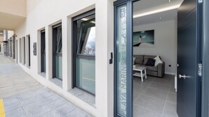 Un bâtiment moderne doté d’une façade en verre, d’un espace d’accueil avec un canapé et d’une porte portant l’inscription « PLAYA MARINAS ».