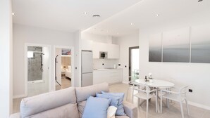 A modern interior with a sofa, dining table, and kitchen area. - Apartment '2-Bed Antares' with Shared Pool, Wi-Fi, and Air Conditioning (Torre del Mar)
