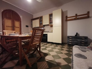 Una cucina con tavolo, sedie e pensili.