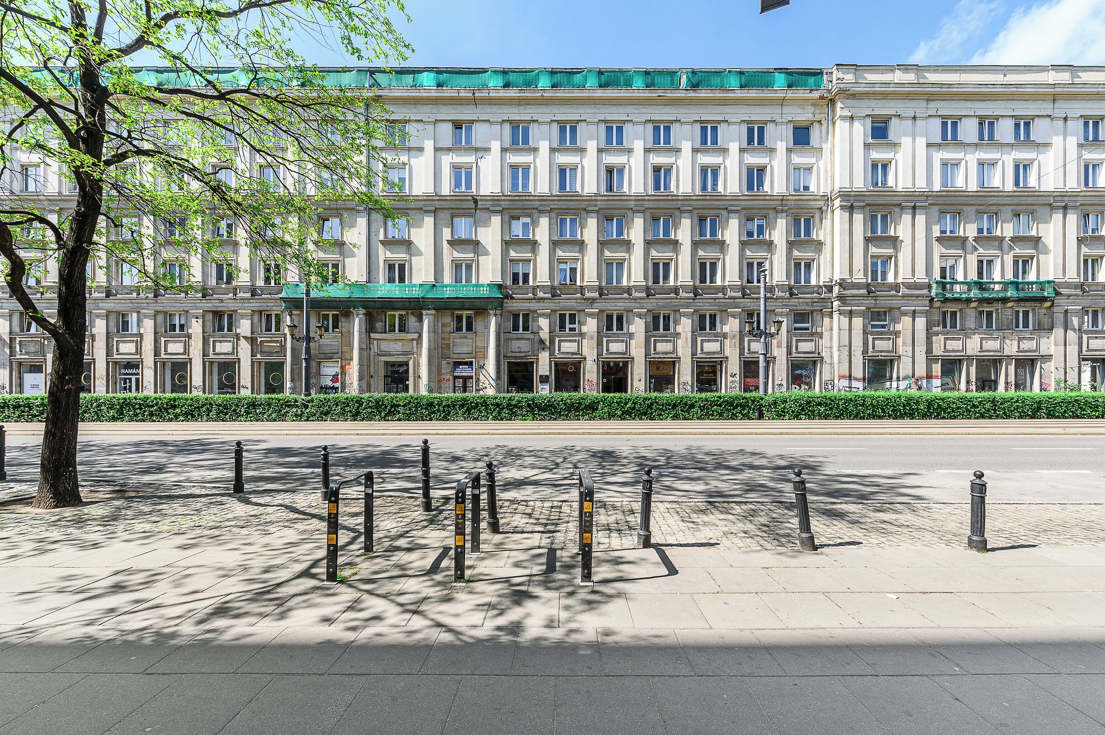 A large, multi-story building with a symmetrical facade, featuring evenly spaced windows and a central entrance.