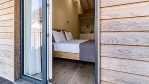 A bedroom with a bed, a bedside table, and a window. - 'Avó Custódia - Room' with Mountain View, Wi-Fi and Air Conditioning (Terras de Bouro)