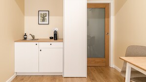 A compact kitchen with a sink, a coffee maker, and a cabinet. - 'Avó Custódia - Room' with Mountain View, Wi-Fi and Air Conditioning (Terras de Bouro)