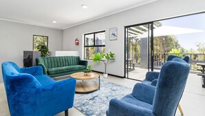 Ein modernes Wohnzimmer mit einem grünen Sofa, blauen Sesseln und einem Couchtisch.