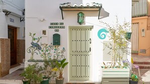 A building with a green door, potted plants, and a sign reading 'CASA EL CAMALEON 28'. - Holiday Home 'Casa El Camaleón' with Wi-Fi and Air Conditioning (Almuñecar)