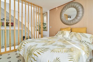 Une chambre à coucher avec un lit, un grand miroir, une cloison en bois et un escalier.