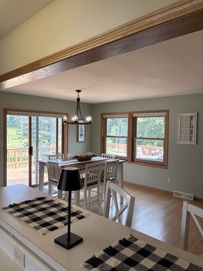 A spacious dining area with a high ceiling, large windows, and a chandelier. - Golf Course Views & Family Fun – Large Apple Canyon Lake Vacation Home (Apple River)