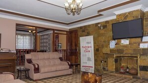 A lobby with a sofa, a piano, a fireplace, and a banner reading "Partners for Care."