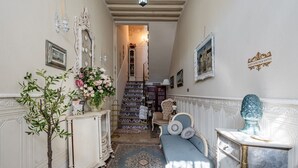 Un corridoio con un divano, un armadio, una scala e una parete decorativa.
